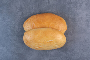 Couple of oval buns displayed on marble background