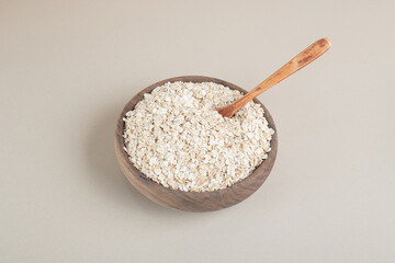 Muesli in a wooden cup on a concrete background