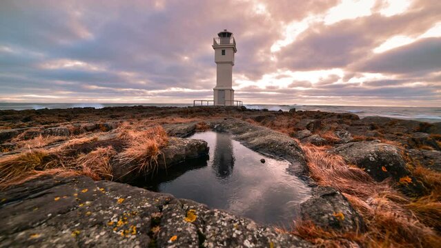 Timelapse of Old lighthouse with reflectionin ice and moving cloudse - Iceland, Akranes time lapse