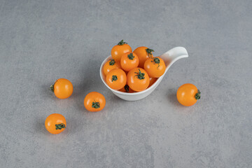 Yellow tomatoes isolated on stone background