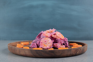 Purple beetroot and carrot salad on a wooden board