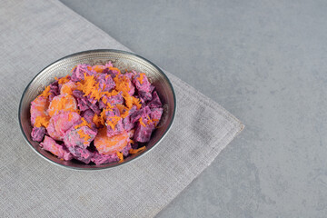 Purple beetroot and carrot salad on a wooden board