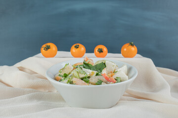 Mixed ingredient vegetable and fruit salad in a white cup