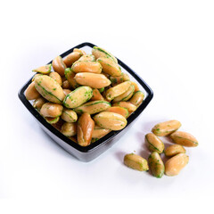 pile of salted peanuts with wasabi in dark glass bowl on white background 