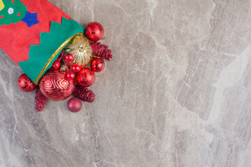 Decorations spilling out of a christmas sock on marble background