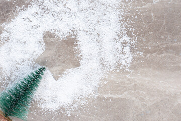 Star-print in a pile of vanilla powder and a tree figurine on marble background