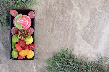 Dessert platter and cypress branches on marble background