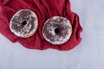 Glazed donuts on tablecloth on white background