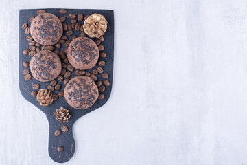 Bundle of cookies and coffee beans on a board on white background