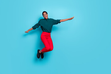 Fototapeta na wymiar Photo of funky attractive androgynous human wear green shirt jumping high empty space isolated blue color background
