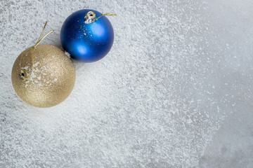 Decorative christmas balls sitting in coconut powder on marble background