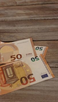 Vertical video of bank notes falling to a table like rain