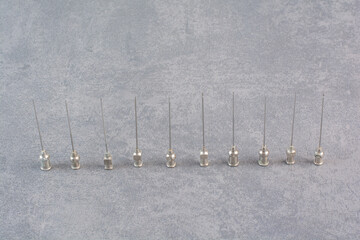 Bunch of metal syringe tips on marble background