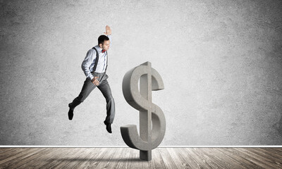 Determined banker man in empty concrete room breaking dollar figure