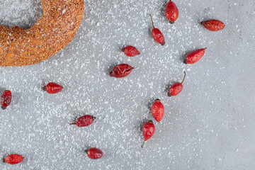 Bagel and dog rose on marble background