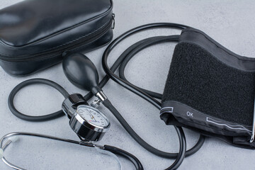 Blood pressure meter and stethoscope on marble surface