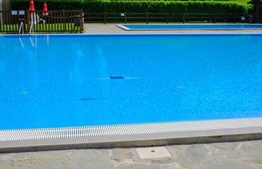 two swimming pools on a sunny day. Poolside Water surface. Hotel resort. Summertime activities
