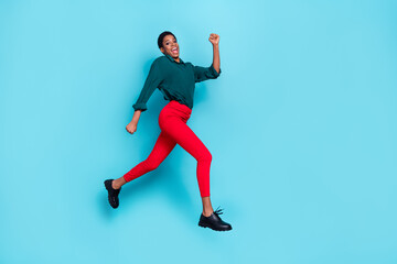Photo of pretty sweet trans person dressed green shirt jumping high running fast empty space isolated blue color background