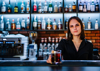 Portrait of young attractive woman bartender Making Cocktail in bar