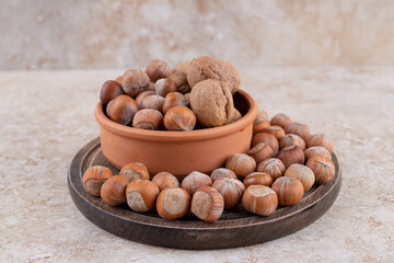 A wooden board full of healthy macadamia nuts