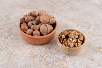 Various nuts on wooden bowl on marble background