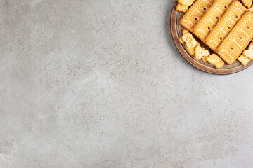 A wooden board full of biscuits on marble background