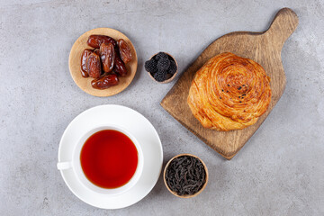 A wooden cutting board of gohal and dates on marble background