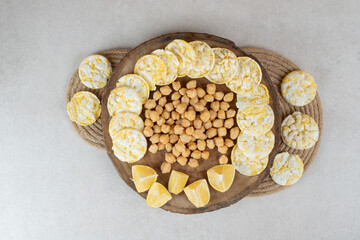 Boiled peas, rice cakes and lemons on wooden piece