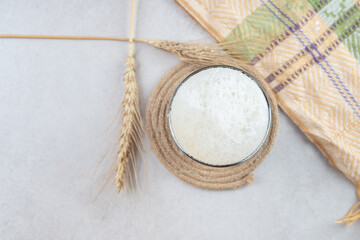 Glass of beer with wheat on stone surface