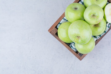 Green tasty apples in wooden basket