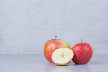 Two whole apple with slices on white background