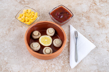 Fototapeta na wymiar Small bowls of mushrooms, red sauce and corn kernels on marble background