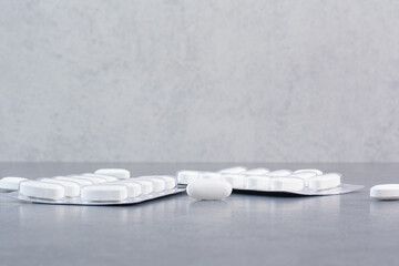 Fototapeta na wymiar Two packs of white pills on marble background