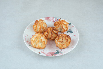 A white plate full of round sweet cookies on white background
