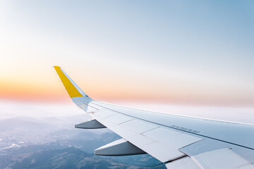 Plane wing in cloudy sky