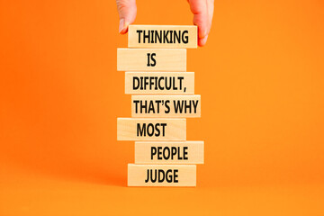 Thinking or judge symbol. Concept words Thinking is difficult that is why most people judge on blocks. Psychologist hand. Beautiful orange background. Business thinking or judge concept. Copy space.