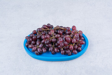 Obraz na płótnie Canvas Fresh sweet grapes in blue plate on white background