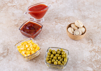 Small portions of Dressings and salad ingredients on marble background