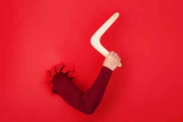 boomerang in hand over red background