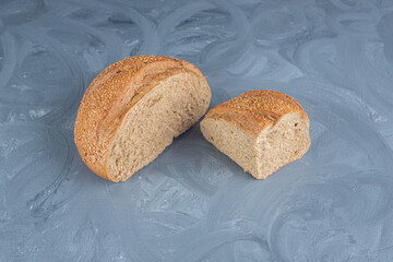 Sliced lumps of sesame covered bread on marble background