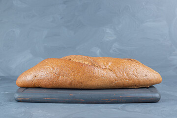 Loaf of bread sitting on a navy tray on marble background