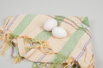 Two fresh chicken white eggs on tablecloth