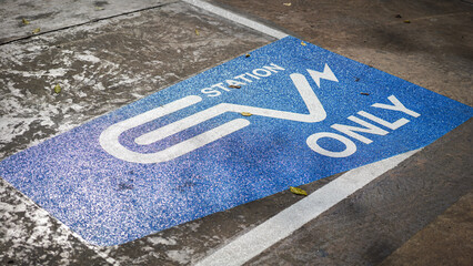 EV station sign on cement ground, reservation for electric car parking lot. Sign and symbol technology object, selective focus.