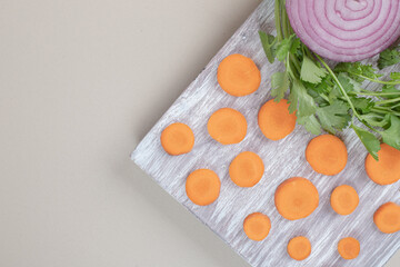 Sliced onion and carrot on wooden cutting board