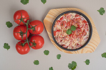 Delicious omelet with tomatoes on wooden board