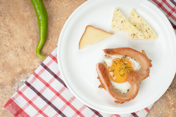 Omelet with sausage in white plate on tablecloth