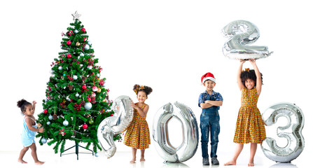 Diverse group of children with metallic silver number balloons 2023 and Christmas trees, Happy new...