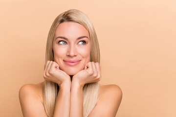 Portrait of attractive dreamy minded woman with pure clean clear skin collagen thinking isolated over beige pastel color background