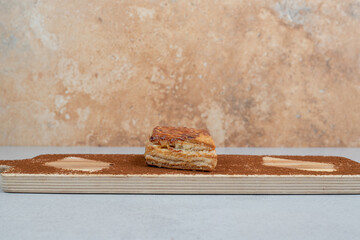 A wooden cutting board with powdered cacao and cookie