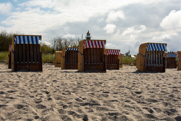 View of wicker  beach baskets  and the lighthouse at Timmendorf Strand on the Baltic Sea, Poel Island, Germany